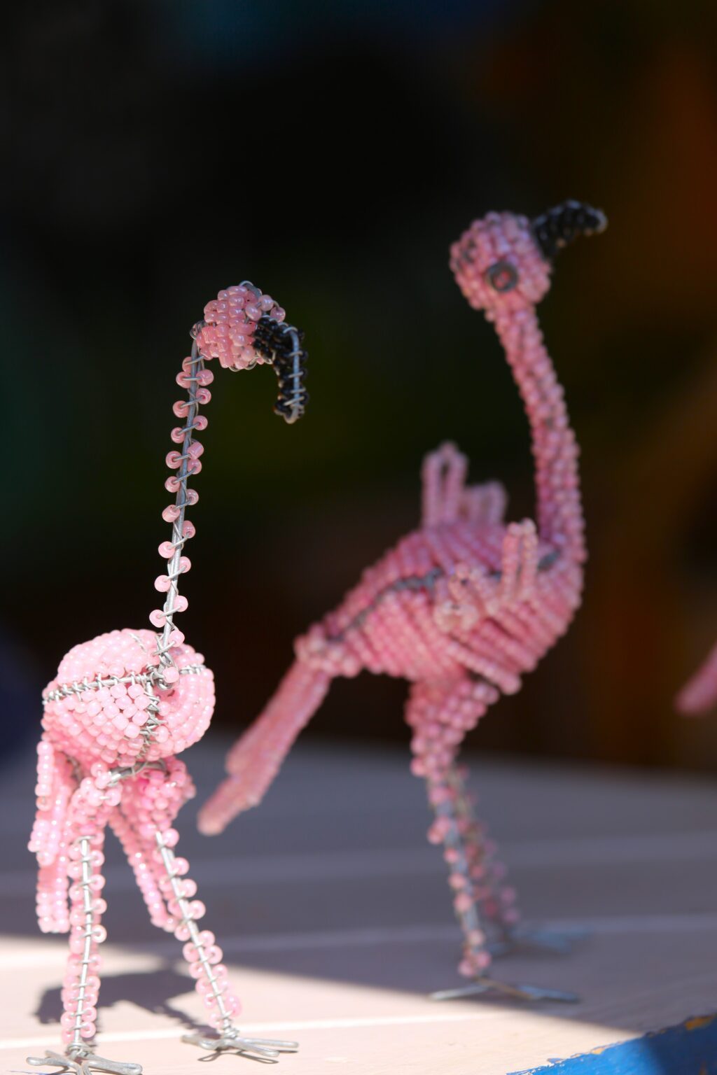 Two pink beaded flamingos built on wire