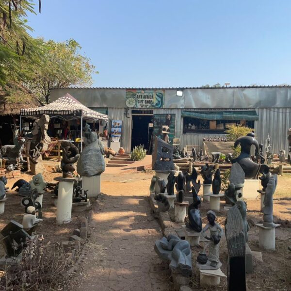 The gift shop building at the sculpture park, sculptures lining the path to the entrance