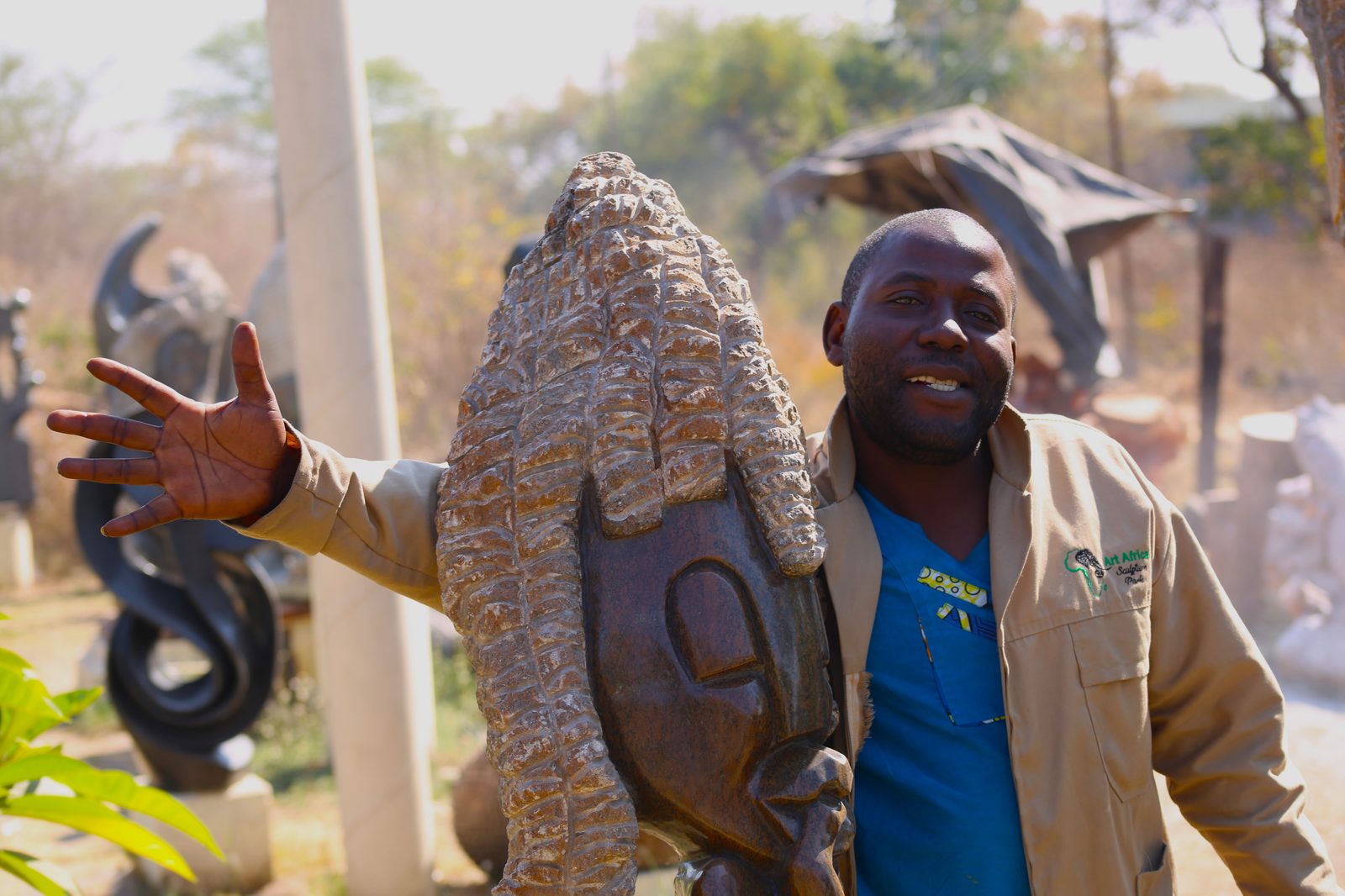 A guide at the sculpture park presenting a carved stone piece