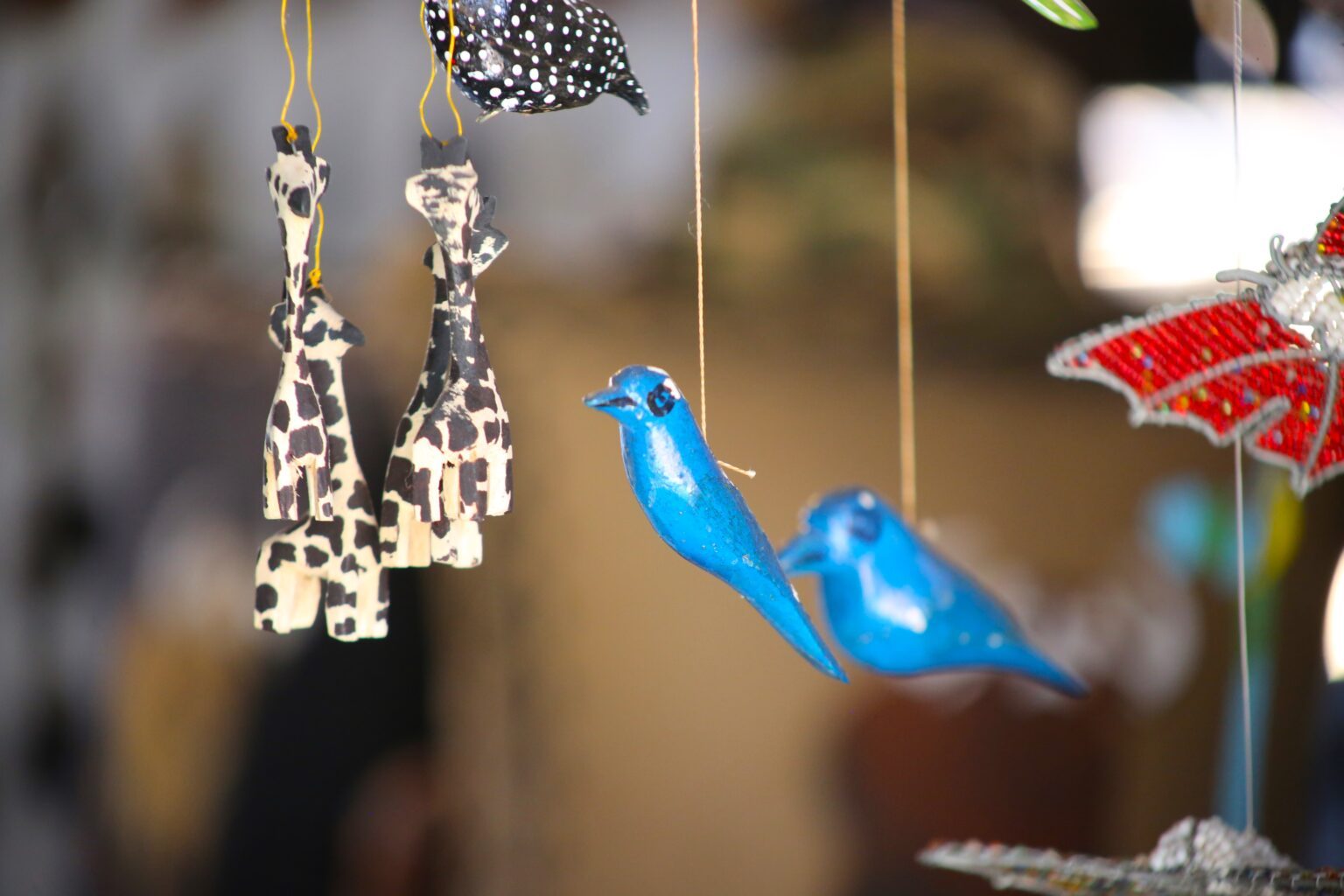 Hanging carved wooden giraffes and birds