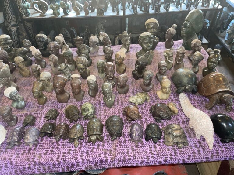 A table of small carved stone busts and tortoises